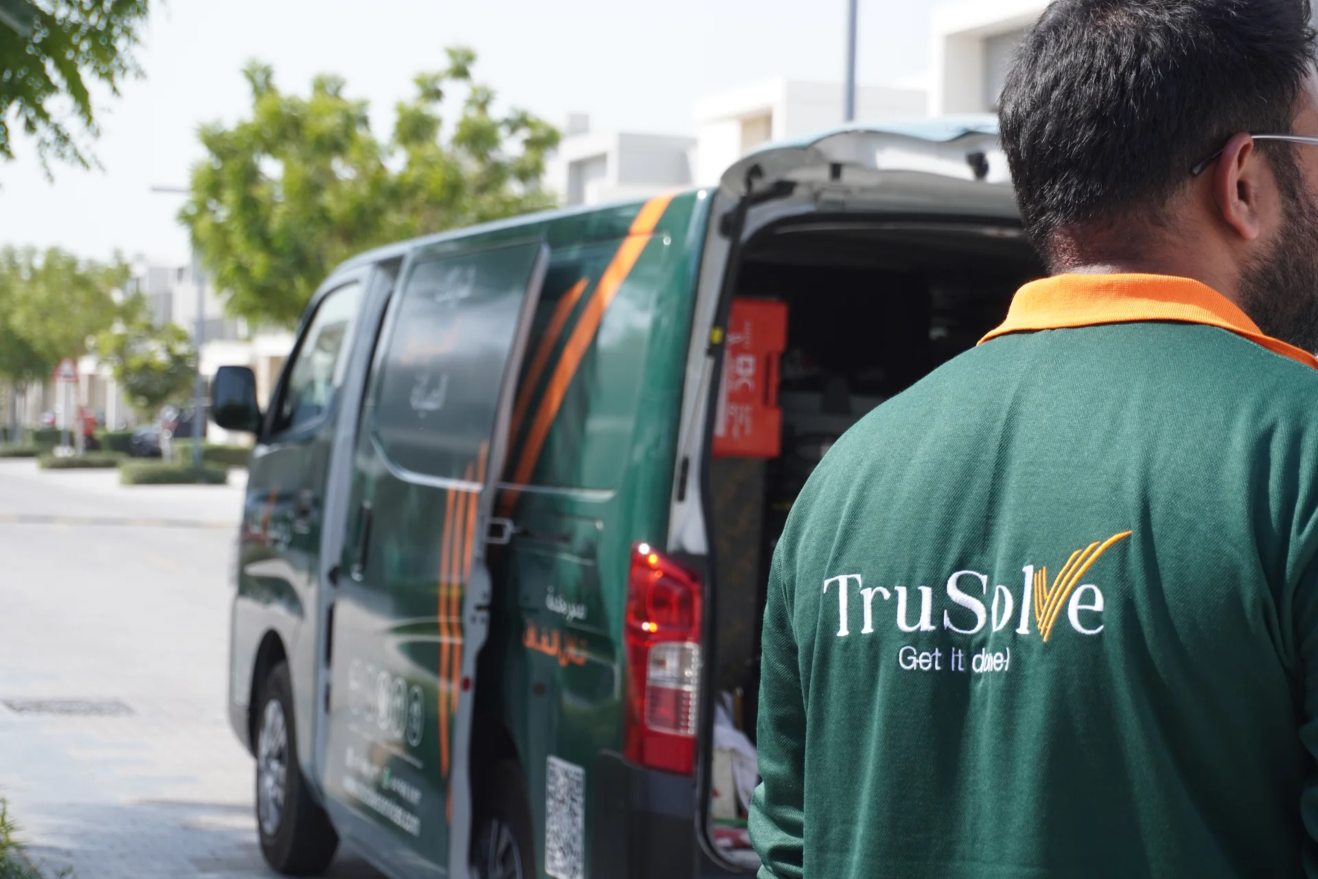 TruSolve technician preparing equipment beside an open service van