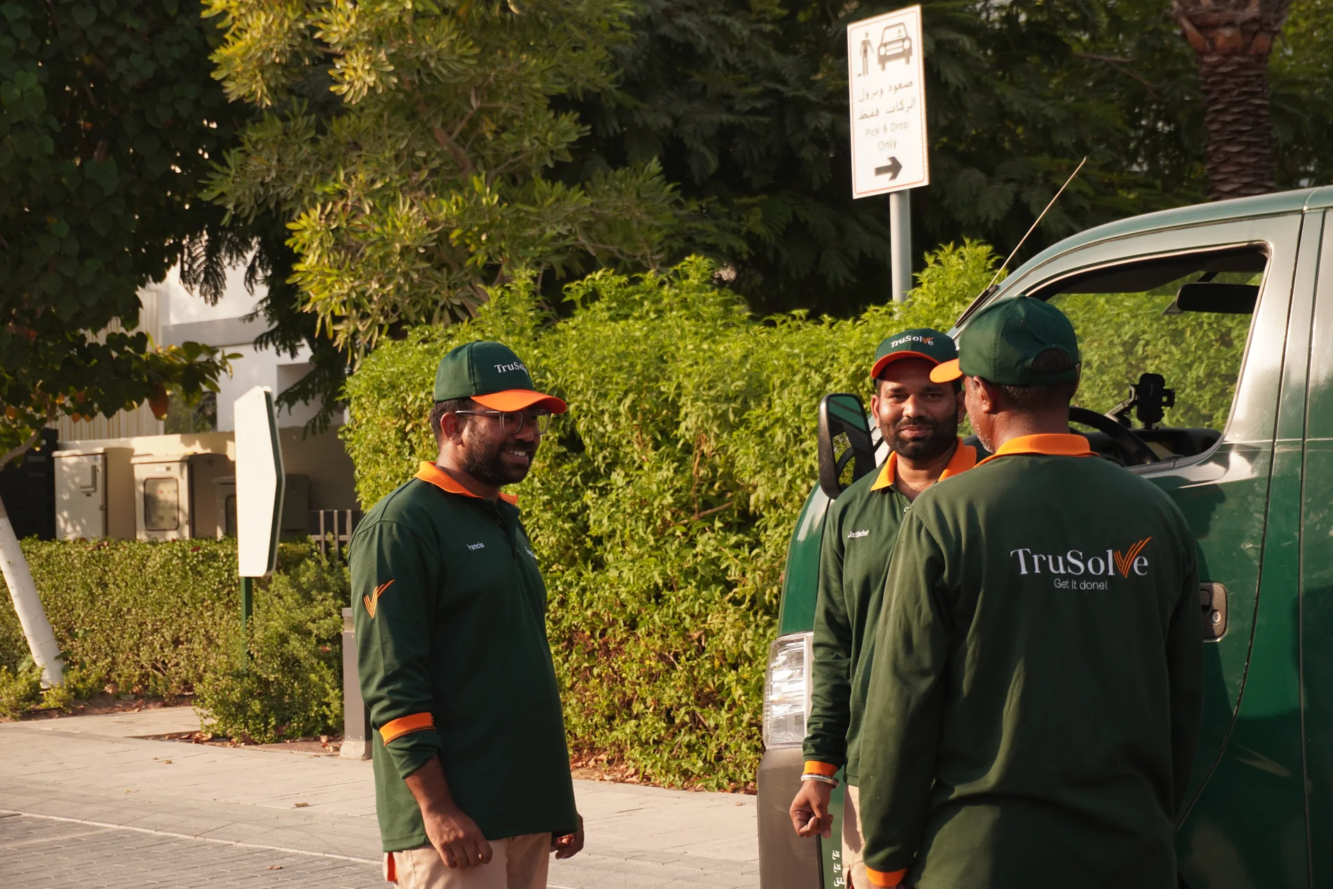 TruSolve team in conversation beside their service vehicle in Dubai